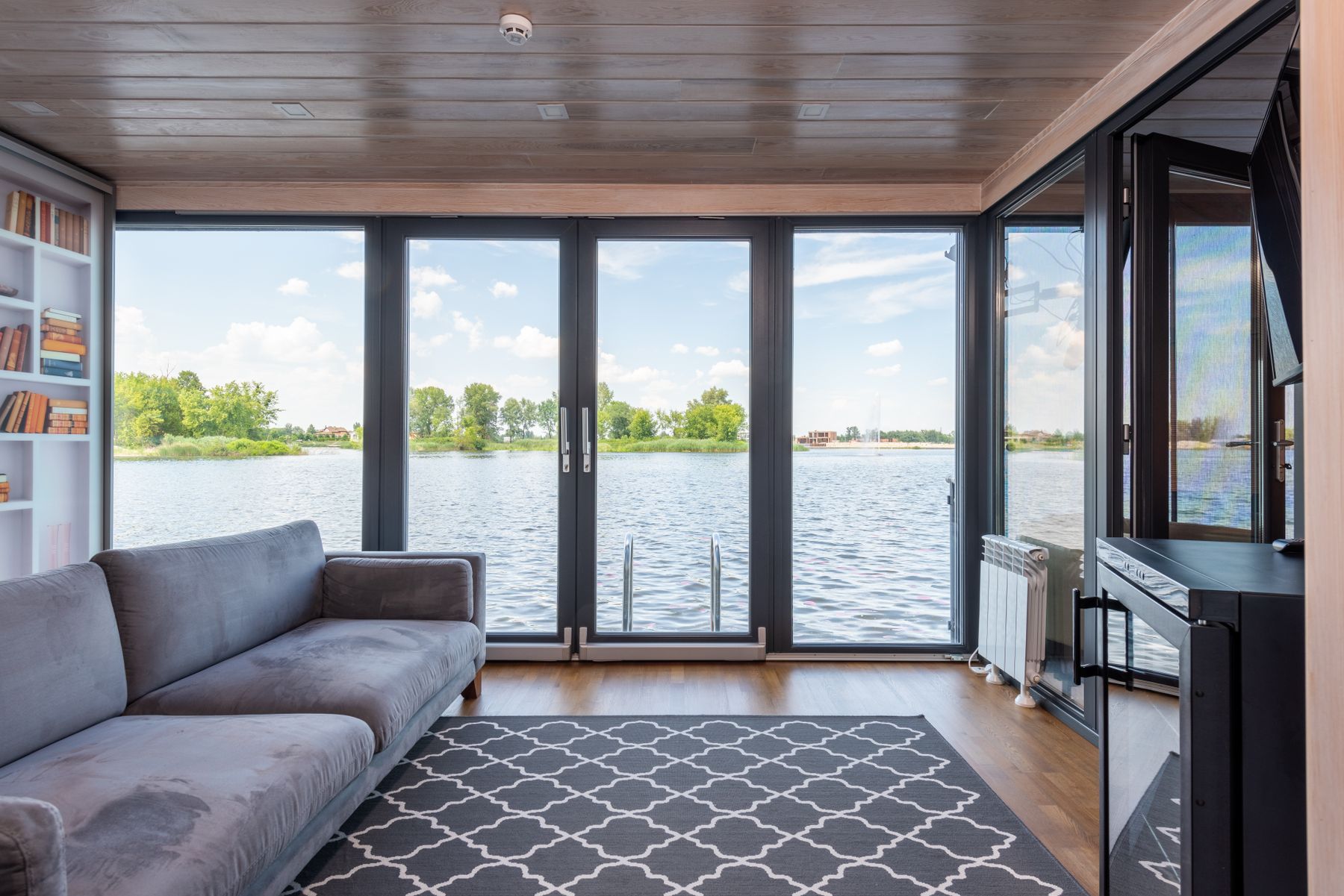 Wohnzimmer mit bodentiefen Fenstern und Seeblick